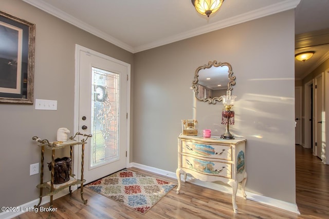 foyer with baseboards, plenty of natural light, wood finished floors, and crown molding