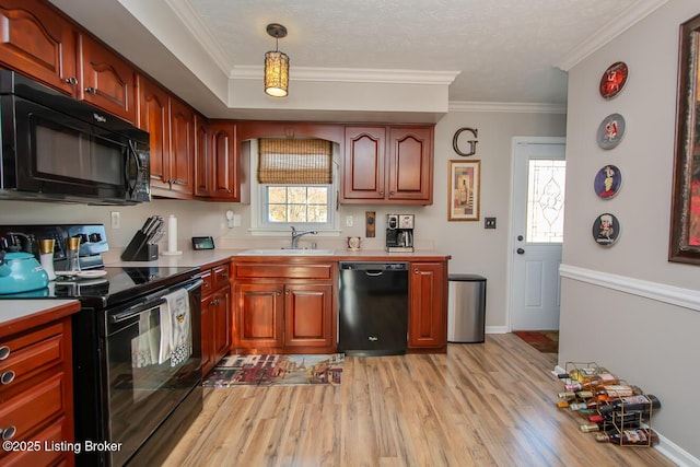 kitchen with black appliances, crown molding, light wood-style flooring, and a sink