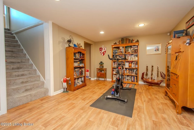 exercise area with baseboards, wood finished floors, and recessed lighting