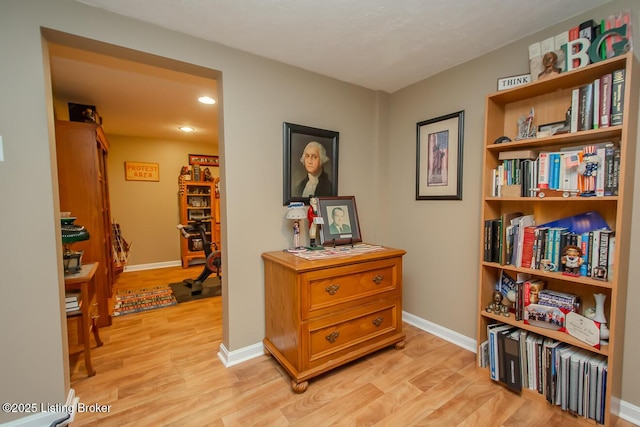 hall with recessed lighting, light wood-style flooring, and baseboards