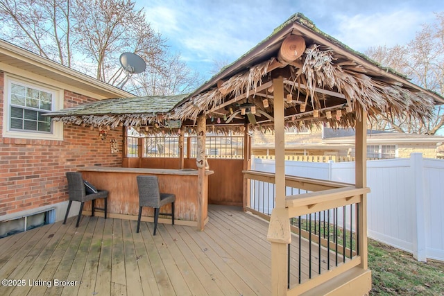 wooden terrace featuring fence and outdoor dry bar