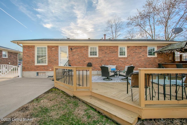 back of house with brick siding and a wooden deck