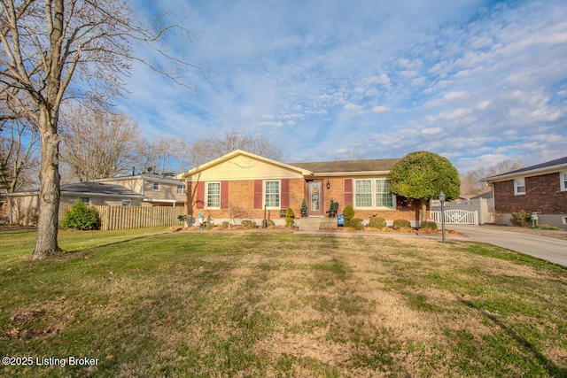 single story home featuring brick siding, a gate, fence, and a front yard