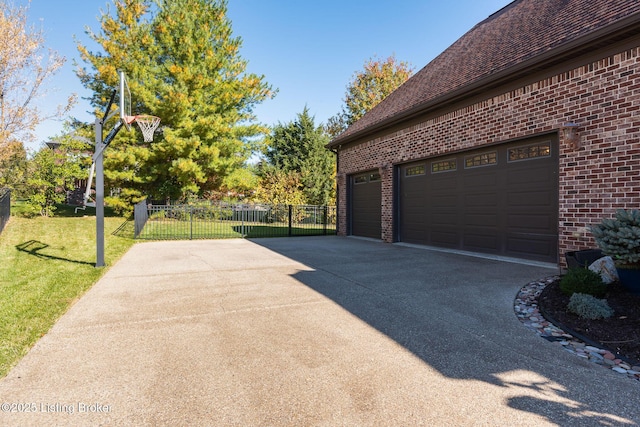 view of home's exterior with a yard, brick siding, fence, and a garage