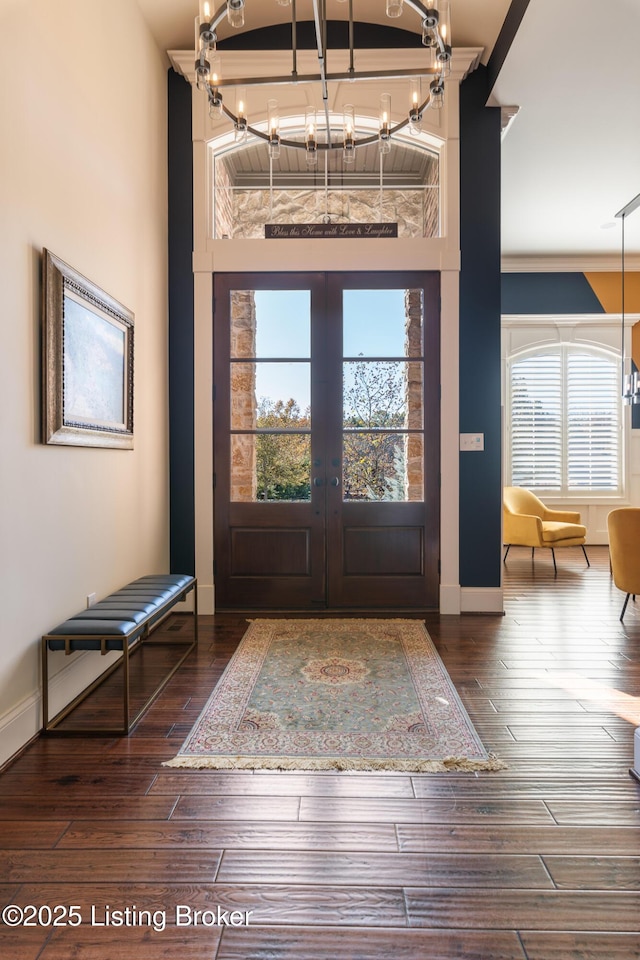 foyer entrance featuring a wealth of natural light, baseboards, dark wood-type flooring, and french doors