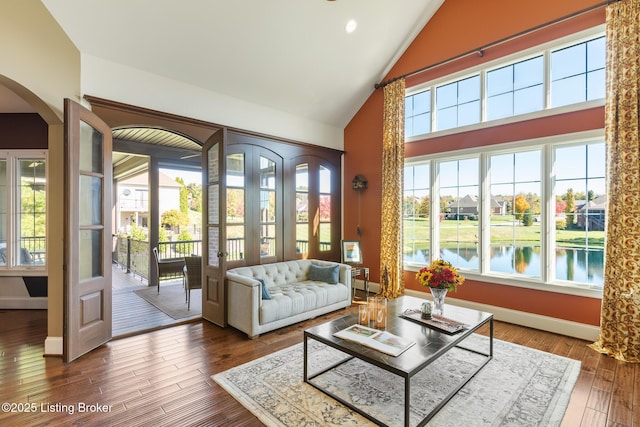 interior space featuring a water view, arched walkways, and vaulted ceiling