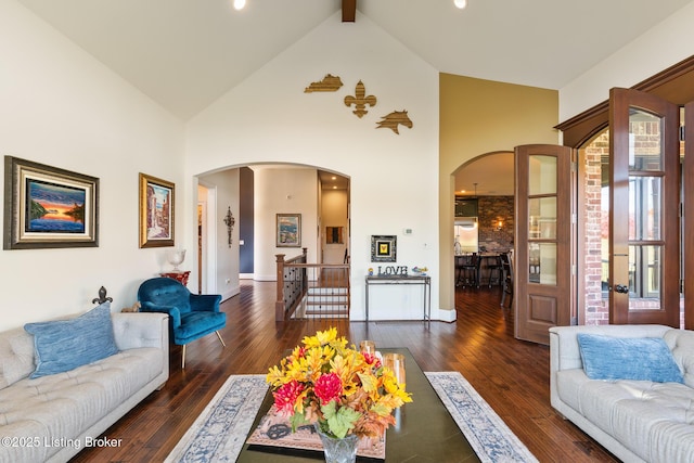 living area with arched walkways, high vaulted ceiling, dark wood-type flooring, baseboards, and beam ceiling