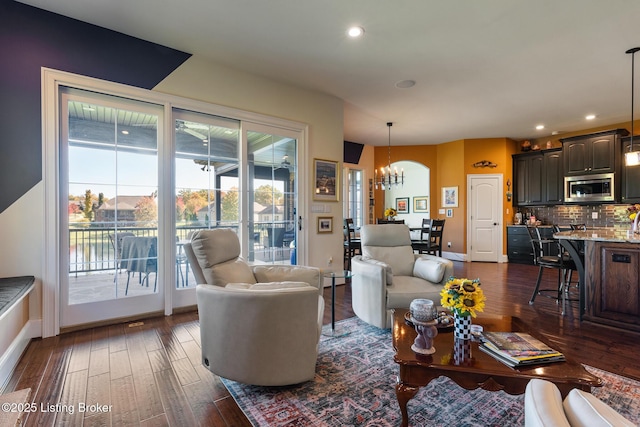 living area featuring a chandelier, dark wood-style flooring, baseboards, and recessed lighting