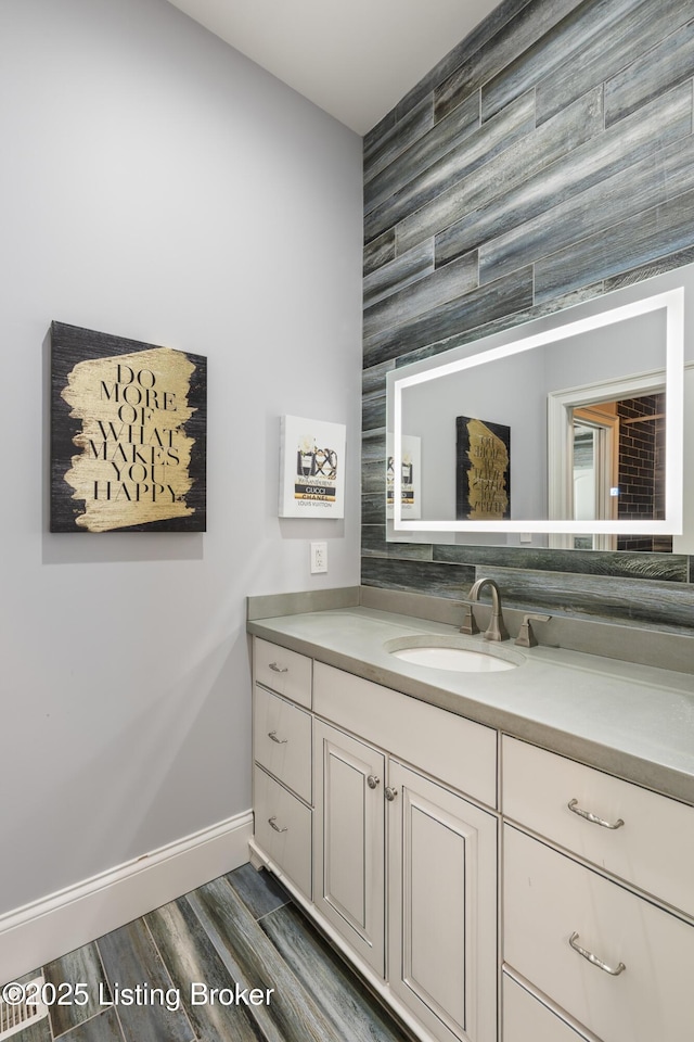 bathroom featuring wood finished floors, vanity, and baseboards