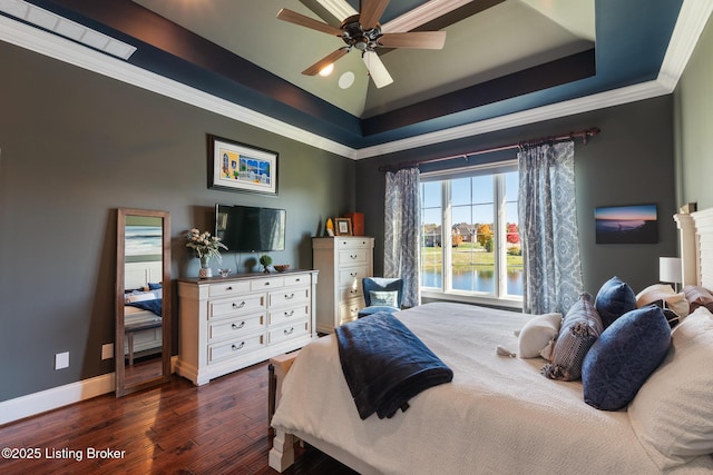 bedroom with baseboards, a raised ceiling, ceiling fan, ornamental molding, and dark wood-style flooring