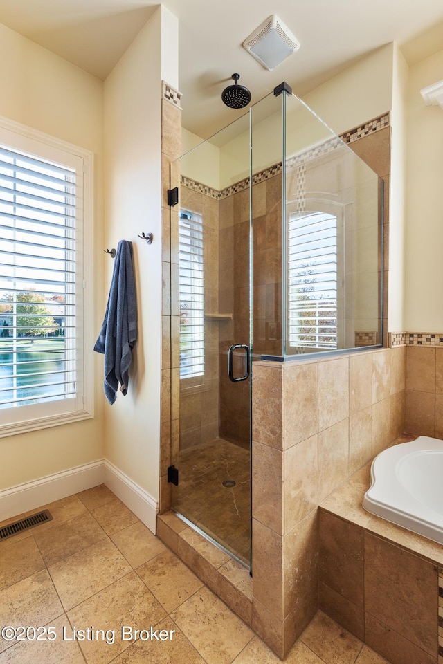 bathroom featuring a healthy amount of sunlight, a stall shower, and visible vents