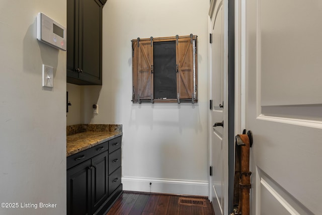 interior space featuring wood-type flooring, visible vents, and baseboards