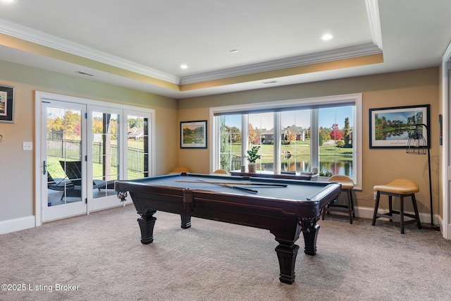 recreation room featuring carpet floors, a raised ceiling, a water view, and crown molding