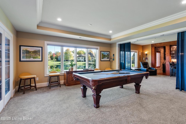 rec room with ornamental molding, a tray ceiling, billiards, and light colored carpet