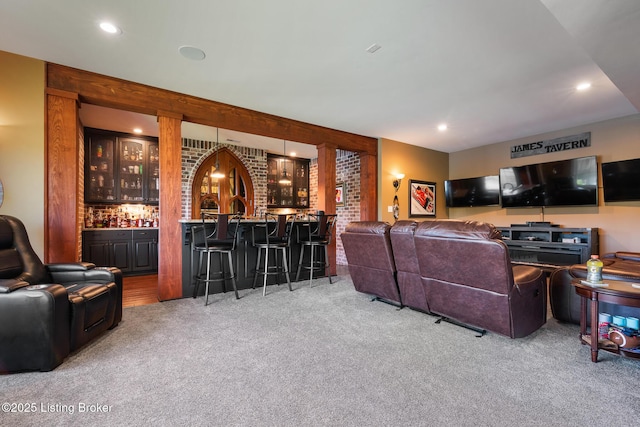 living room featuring wet bar, light carpet, and recessed lighting