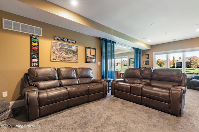 carpeted home theater room featuring visible vents and baseboards