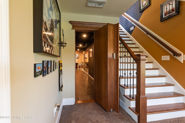 staircase featuring visible vents and carpet flooring