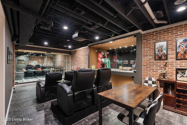 home theater with brick wall and wood finished floors