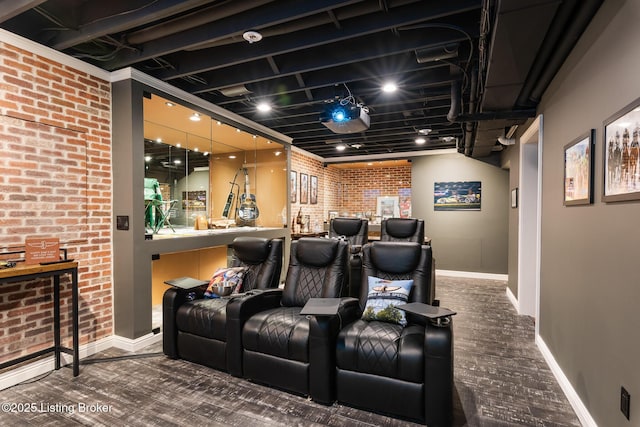 home theater room with baseboards and brick wall