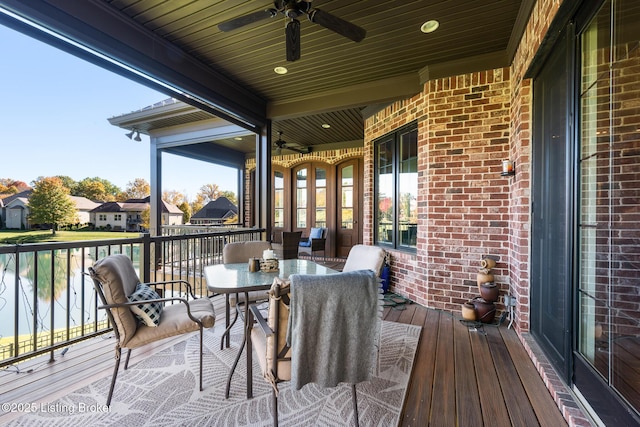 wooden terrace with outdoor dining space and ceiling fan