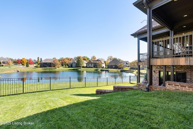 view of yard featuring a residential view, a water view, and a fenced backyard