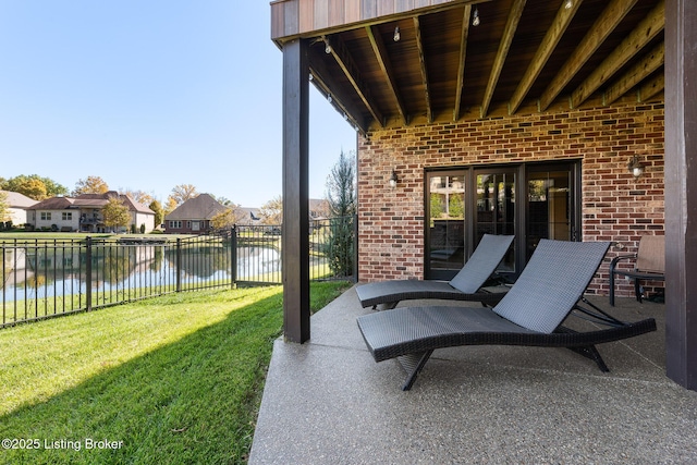 view of patio with a water view, fence, and a residential view