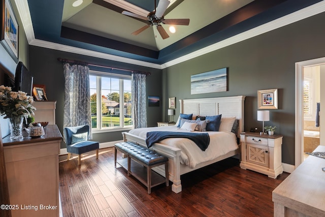 bedroom with dark wood-style floors, a tray ceiling, ornamental molding, and baseboards