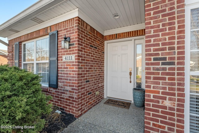 entrance to property featuring brick siding