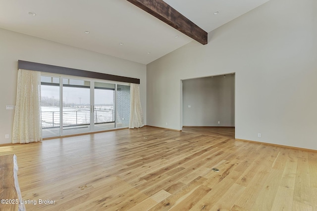 spare room featuring high vaulted ceiling, light wood finished floors, beamed ceiling, and baseboards