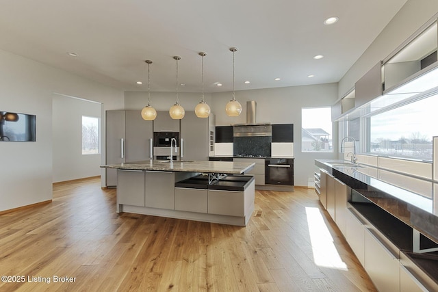 kitchen featuring a sink, ventilation hood, modern cabinets, light wood-type flooring, and oven