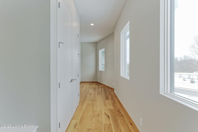 hall featuring a healthy amount of sunlight, light wood finished floors, and recessed lighting