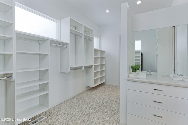 spacious closet featuring visible vents and light colored carpet