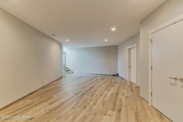 spare room with light wood-style flooring, recessed lighting, visible vents, and stairway