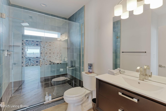 bathroom with vanity, a tile shower, and toilet