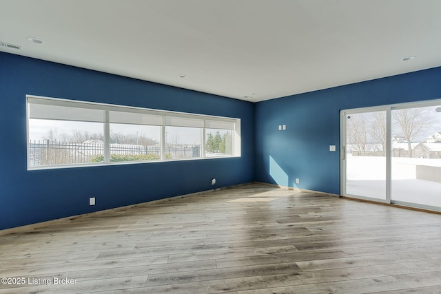 spare room featuring visible vents and wood finished floors