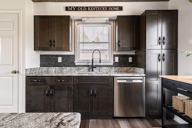 kitchen with decorative backsplash, dishwasher, light stone counters, dark brown cabinets, and a sink