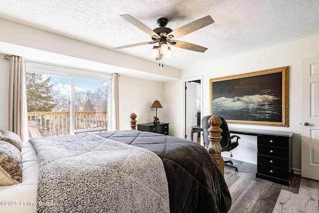 bedroom featuring a textured ceiling, ceiling fan, built in desk, and wood finished floors