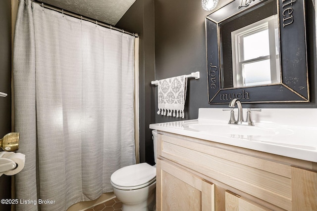 full bath featuring a textured ceiling, vanity, and toilet