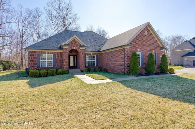 traditional-style home with a shingled roof, brick siding, and a front lawn