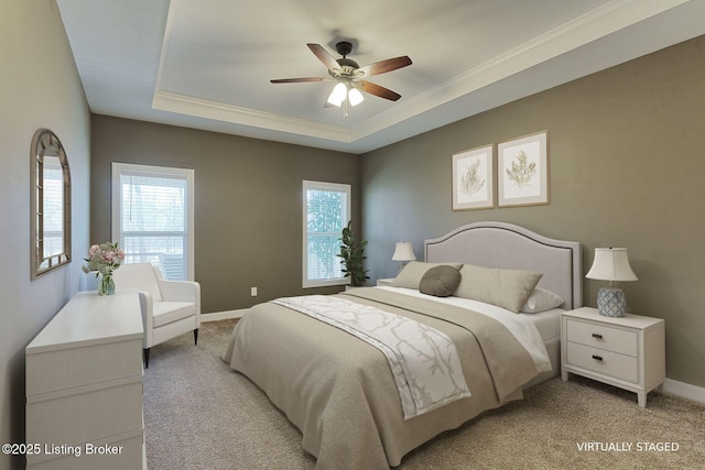 bedroom featuring baseboards, a tray ceiling, ornamental molding, and light colored carpet