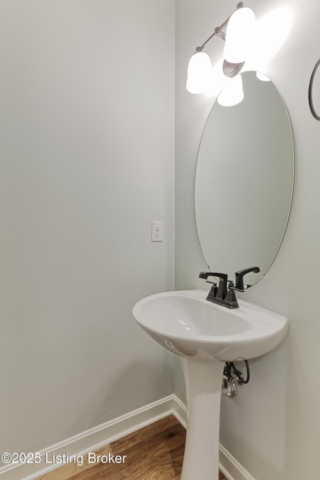 bathroom featuring a sink, baseboards, and wood finished floors