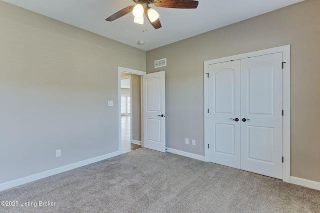 unfurnished bedroom with a closet, visible vents, carpet flooring, ceiling fan, and baseboards