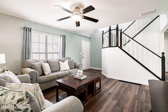 living area with visible vents, a ceiling fan, wood finished floors, stairs, and a textured ceiling