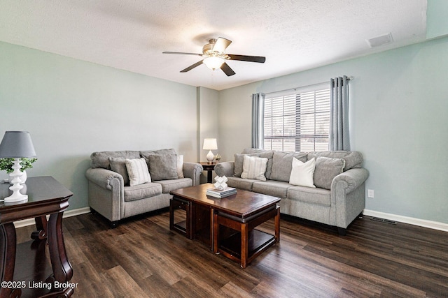 living area featuring a textured ceiling, dark wood-style flooring, a ceiling fan, and baseboards