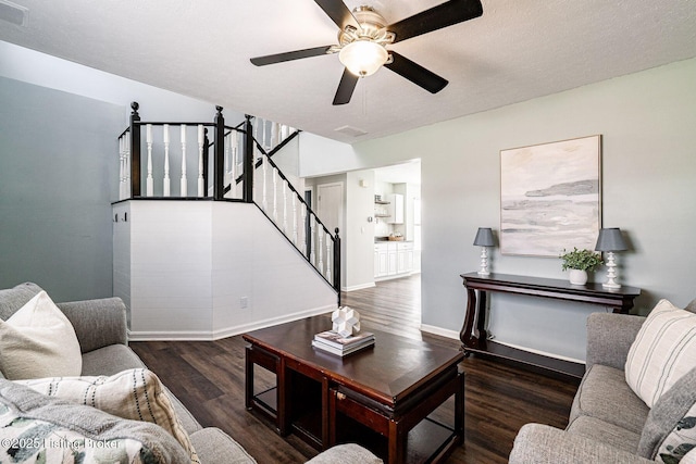 living area with visible vents, baseboards, a ceiling fan, wood finished floors, and stairs