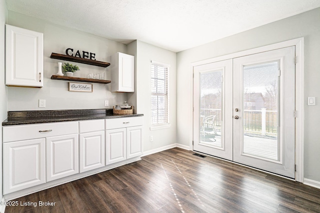 kitchen featuring visible vents, dark countertops, dark wood-style floors, french doors, and white cabinetry