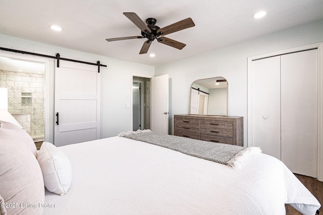 bedroom with recessed lighting, a closet, ensuite bath, and a barn door