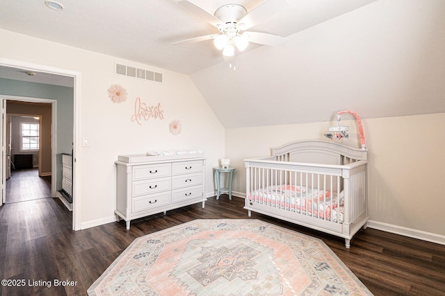 bedroom with lofted ceiling, baseboards, visible vents, and wood finished floors