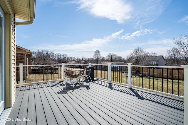 wooden deck with a lawn and fence