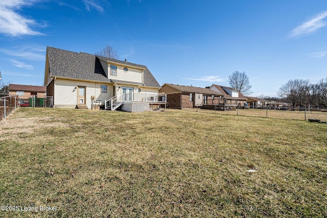 back of house with a deck, a yard, and a fenced backyard